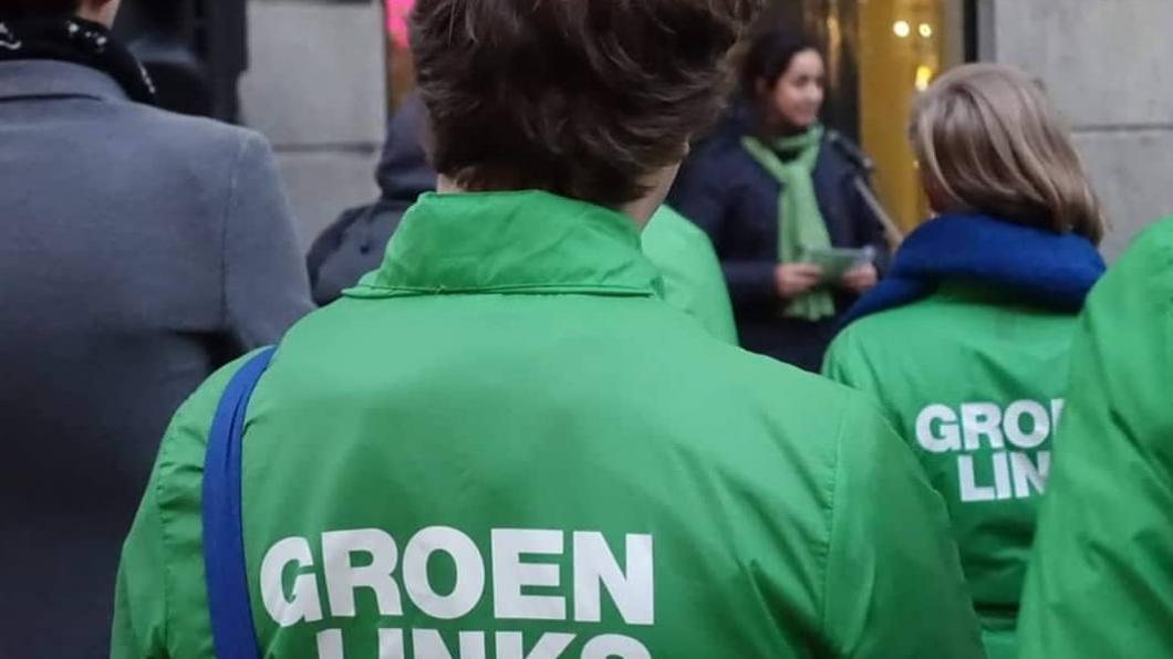 Een GroenLinks-vrijwilliger met een groene campagnejas aan